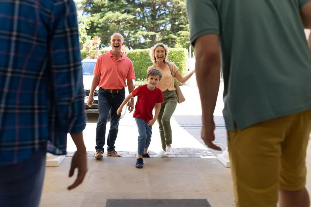 happy people walking up a driveway with a car in the background. 
